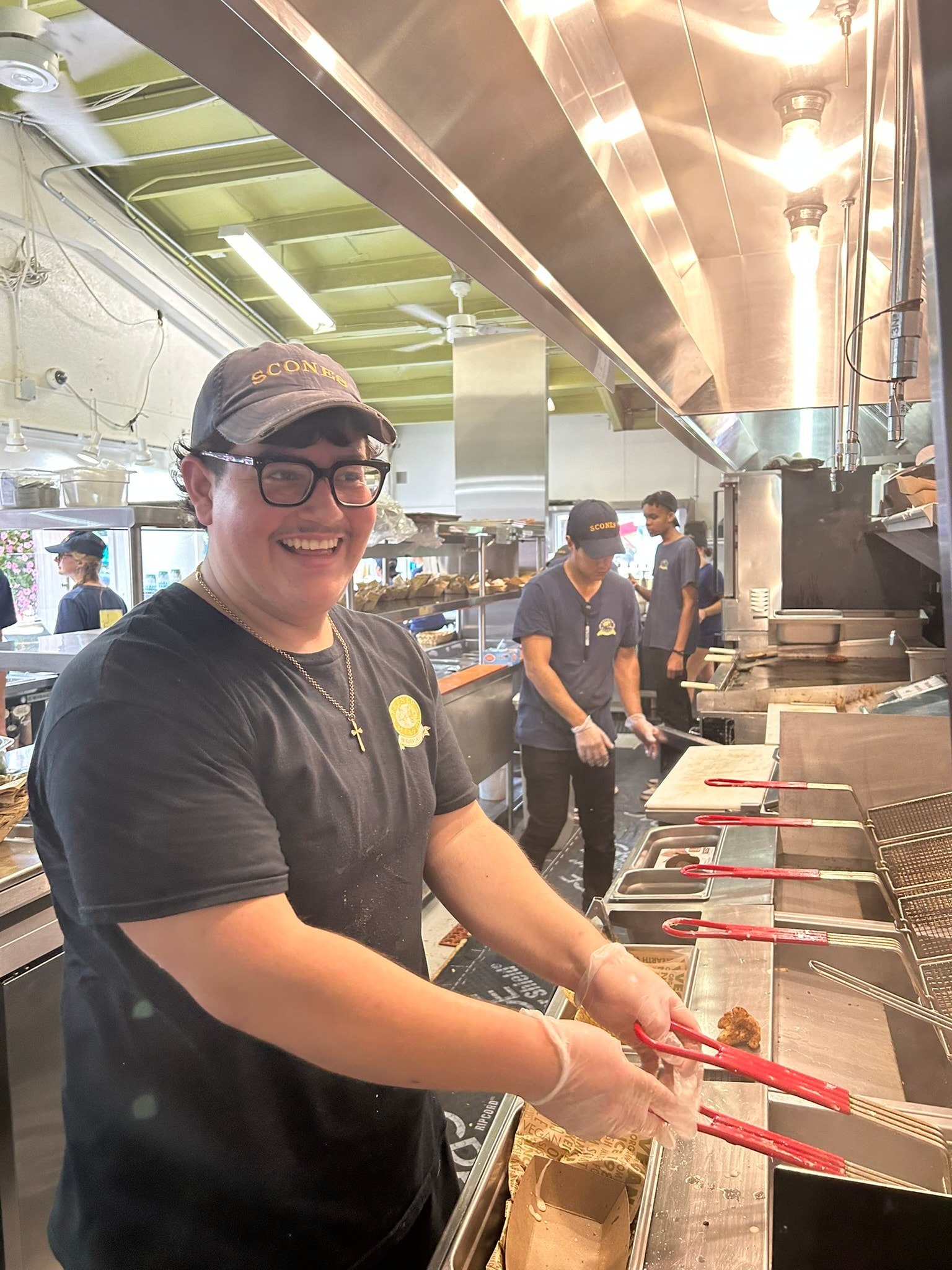 French Meadow staff member working the fryer station with a big smile