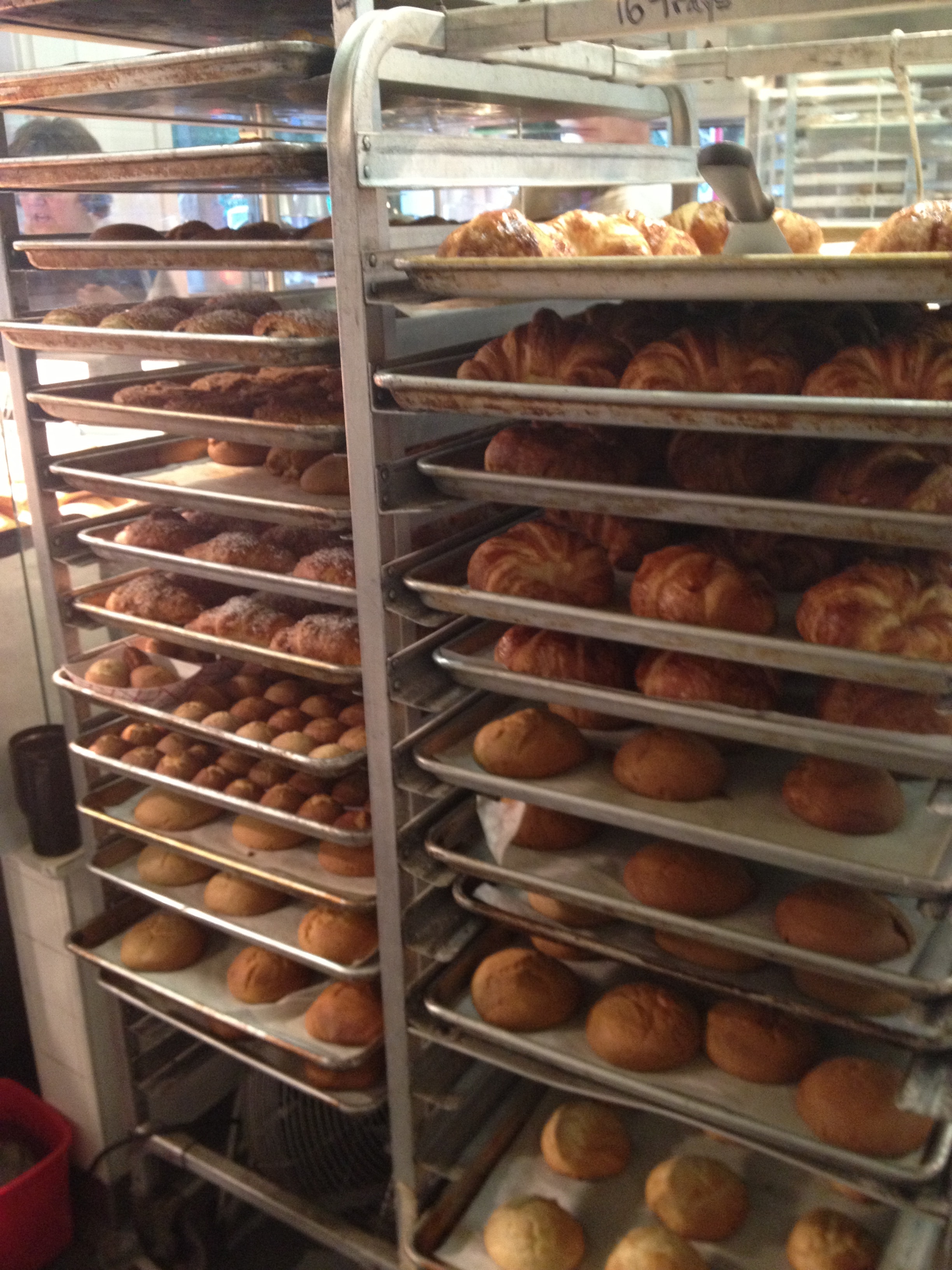 Freshly baked pastries and breads on commercial bakery racks