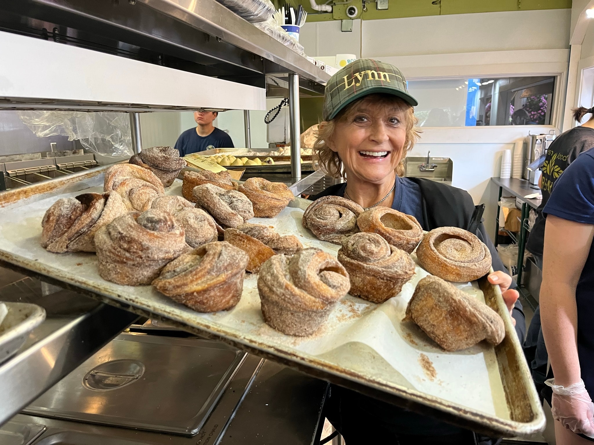 Lynn holding a fresh tray of cinnamon pastries at French Meadow Bakery
